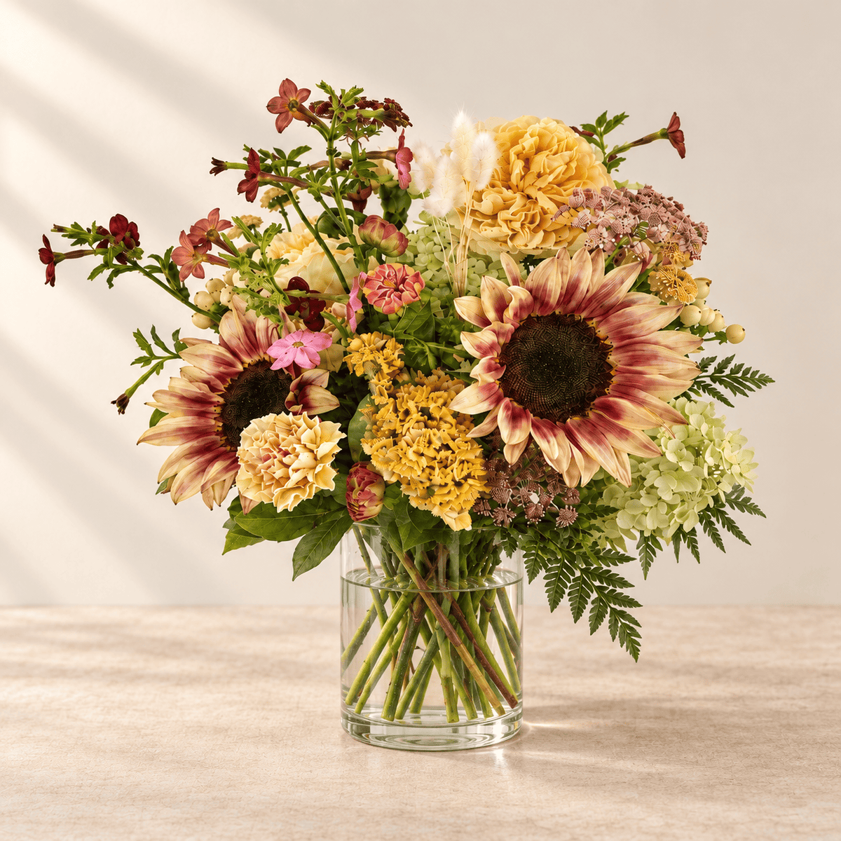 Autumn Designer's Choice flowers arranged in a glass vase.